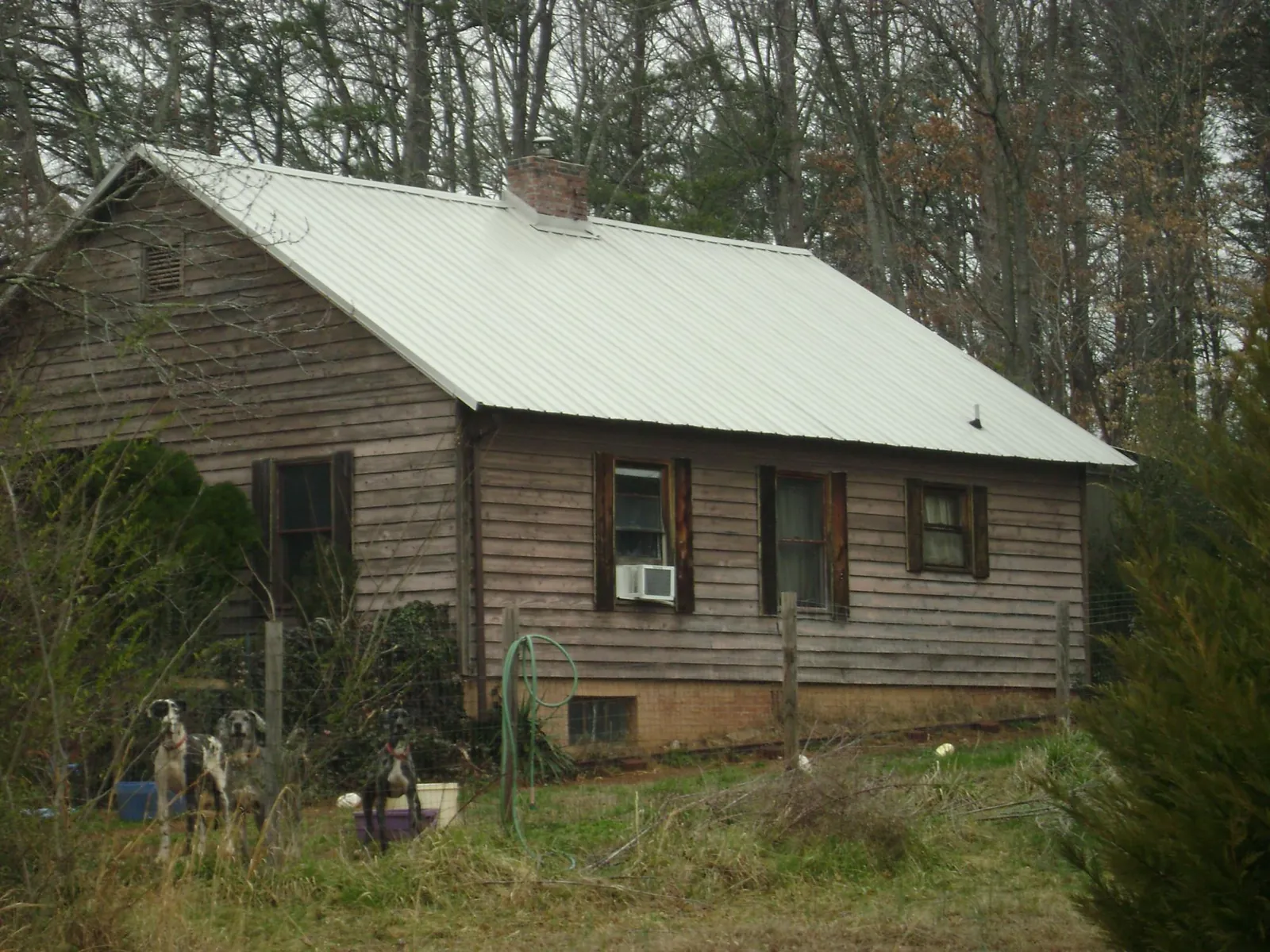 White metal roof on an old wood sided farmhouse, from a Metal Roof Installation job in Lingle